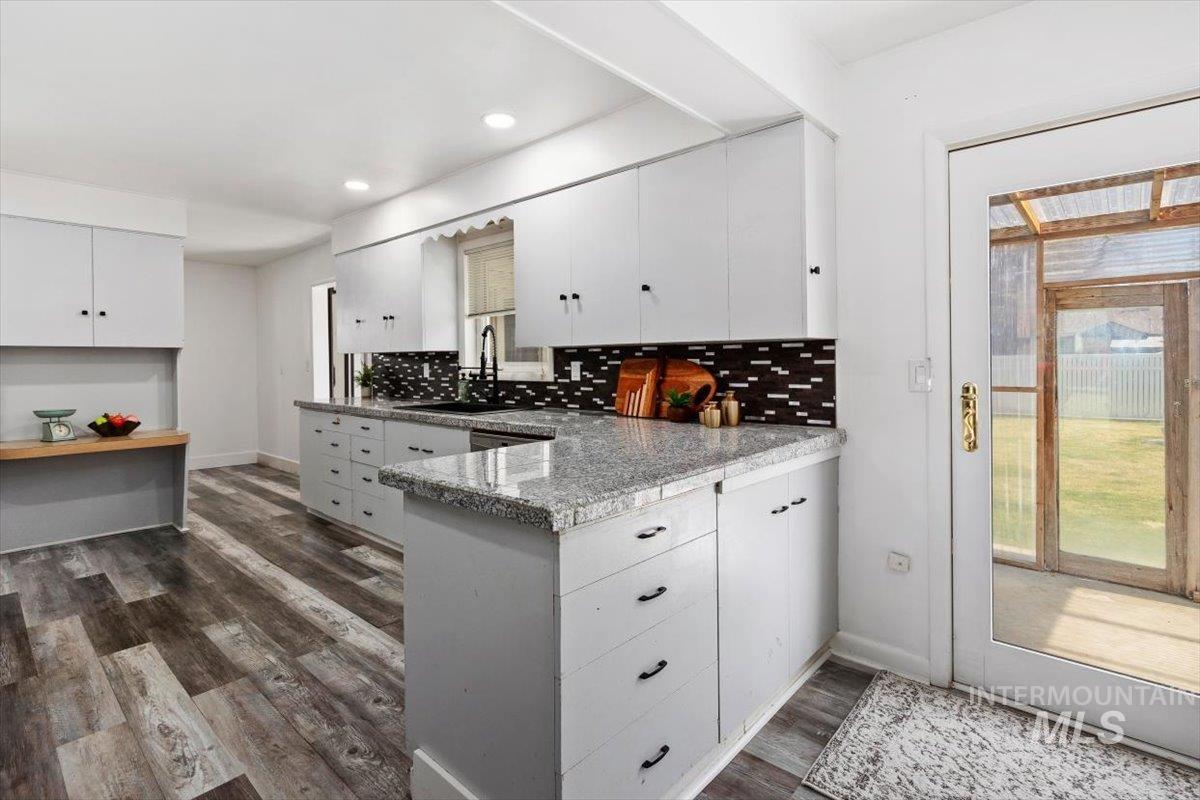 1214 H Street Rupert, ID 83350 - Photo 11 of 35 Kitchen featuring dark wood-type flooring, white cabinets, a peninsula, tasteful backsplash, and recessed lighting