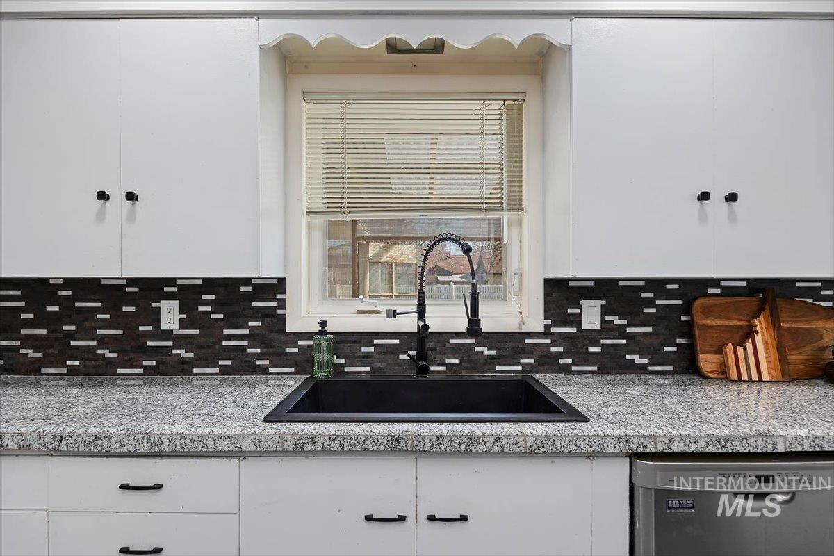 1214 H Street Rupert, ID 83350 - Photo 14 of 35 Kitchen with white cabinetry, stainless steel dishwasher, and light countertops