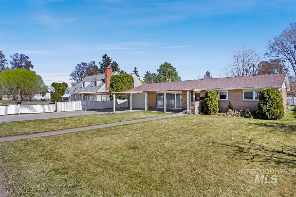 1214 H Street Rupert, ID 83350 - Photo 2 of 35 View of front of property with brick siding, a garage, and driveway