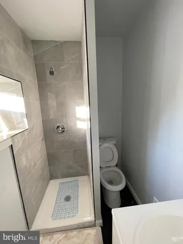 a bathroom with a granite countertop toilet a sink and a shower