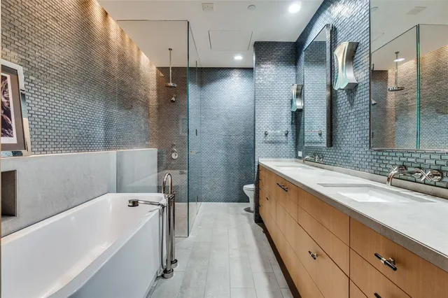 a spacious bathroom with a tub sink shower and mirror