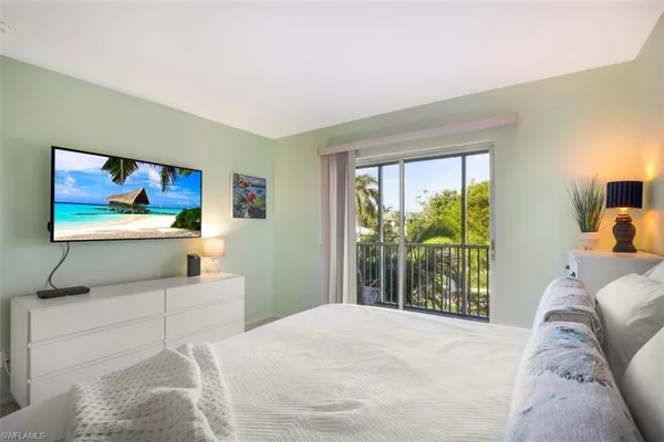 a bedroom with a bed and a large window