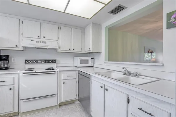 a kitchen with white cabinets sink and white appliances
