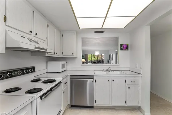 a kitchen with cabinets appliances a sink and a counter top