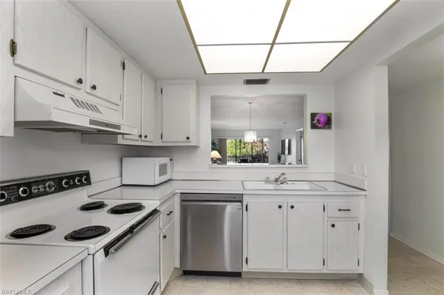 a kitchen with cabinets appliances a sink and a counter top