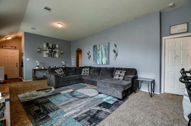 a living room with furniture and wooden floor