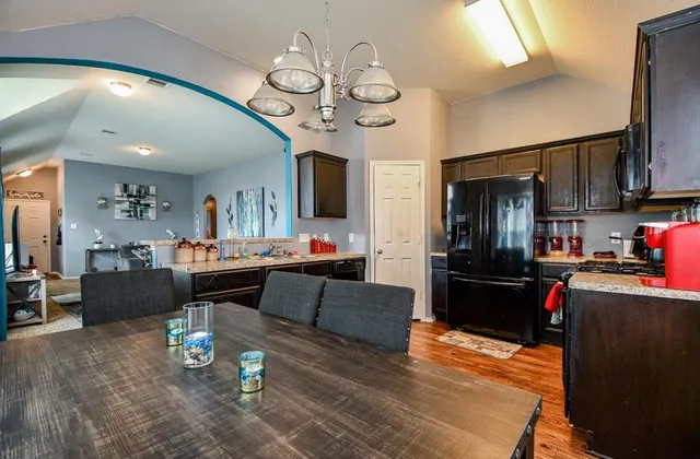 a living room with furniture kitchen view and a wooden floor