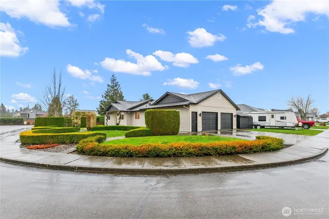 a front view of a house with a garden and trees