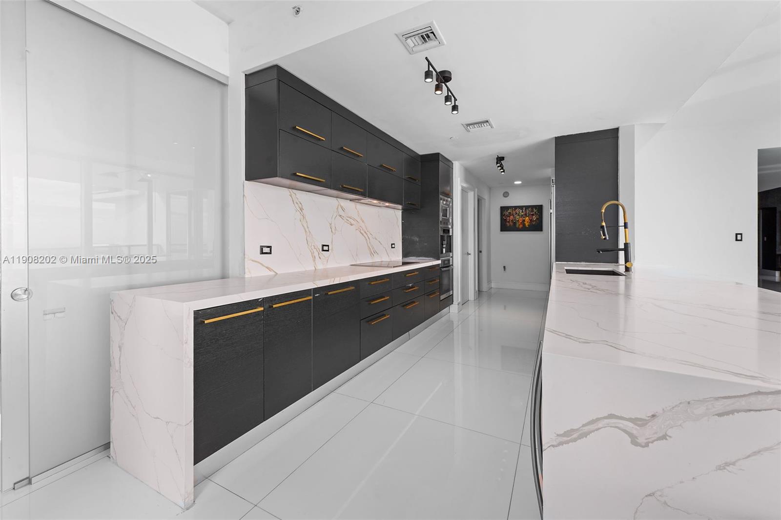 900 Biscayne Boulevard, Unit PH6201 Miami, FL 33132 - Photo 22 of 73 a kitchen with granite countertop a stove and a microwave