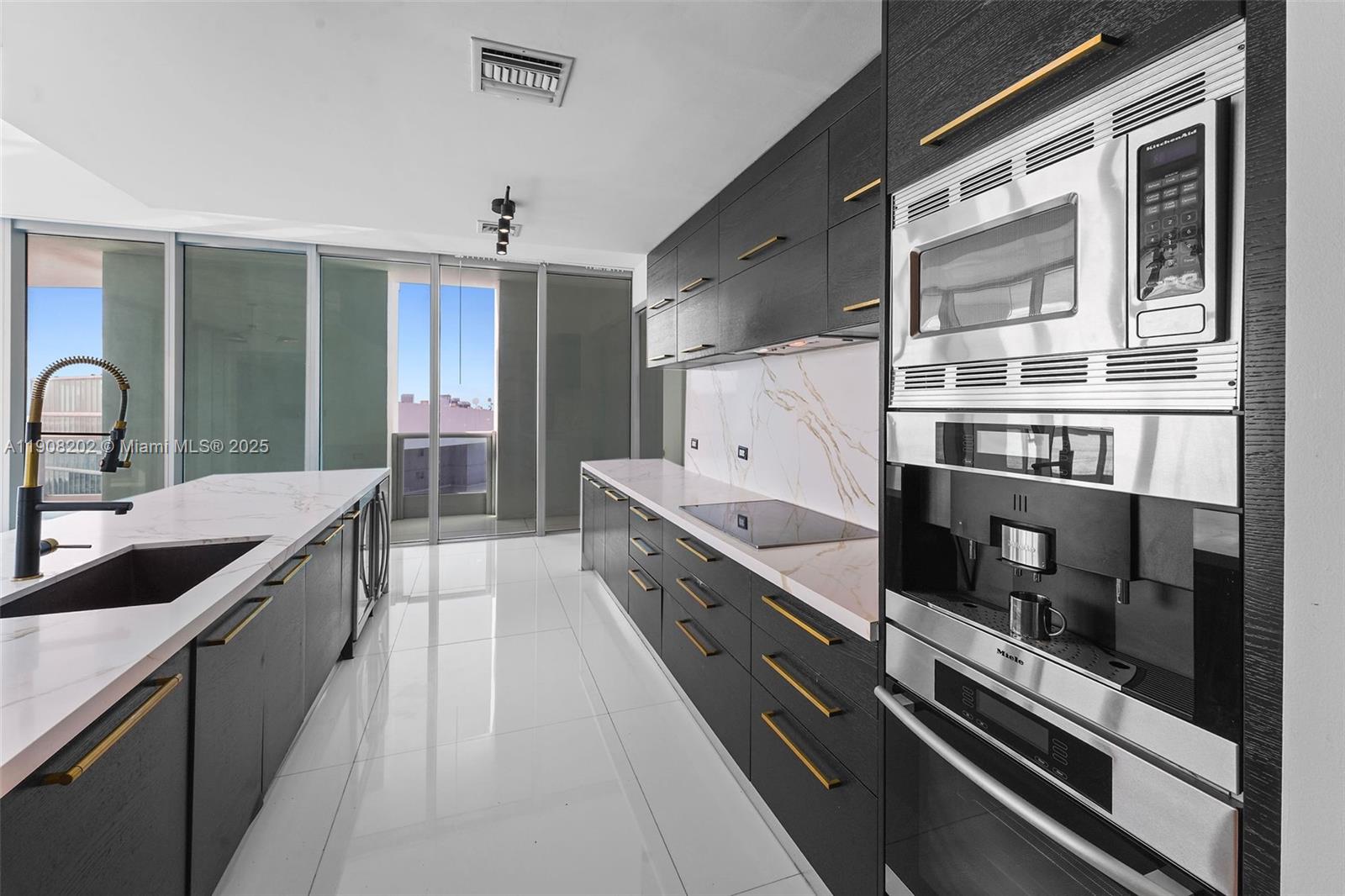 900 Biscayne Boulevard, Unit PH6201 Miami, FL 33132 - Photo 23 of 73 a large kitchen with stainless steel appliances a stove and more cabinets