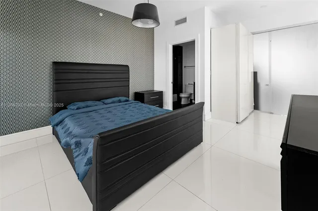 a large white kitchen with a large counter top stainless steel appliances and cabinets