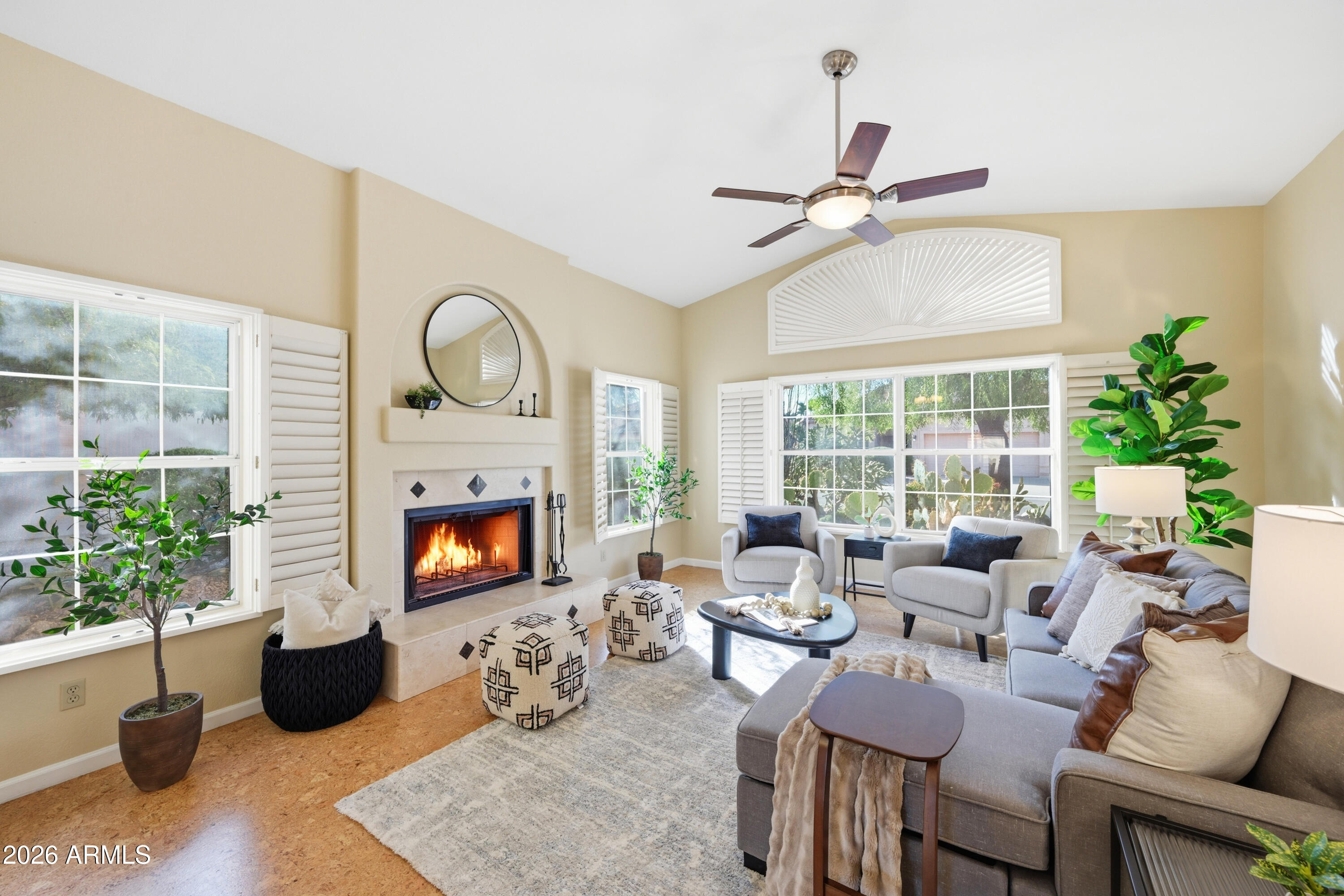a living room with furniture fireplace and a large window