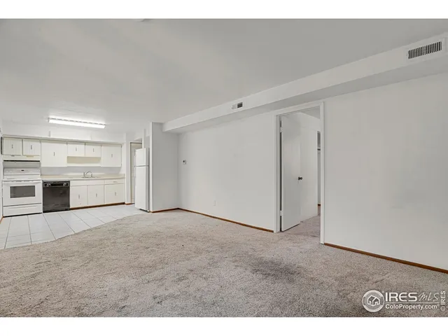 a view of an empty room with a kitchen