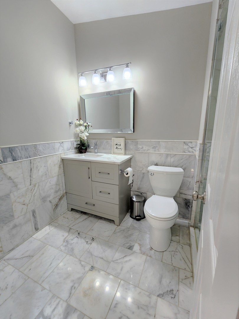 696 Dover Drive Elgin, IL 60120 - Photo 16 of 32 a spacious bathroom with a toilet sink and mirror