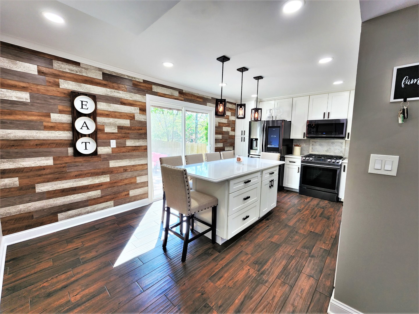 696 Dover Drive Elgin, IL 60120 - Photo 3 of 32 a kitchen with stainless steel appliances kitchen island granite countertop a stove a refrigerator and a dining table with wooden floor
