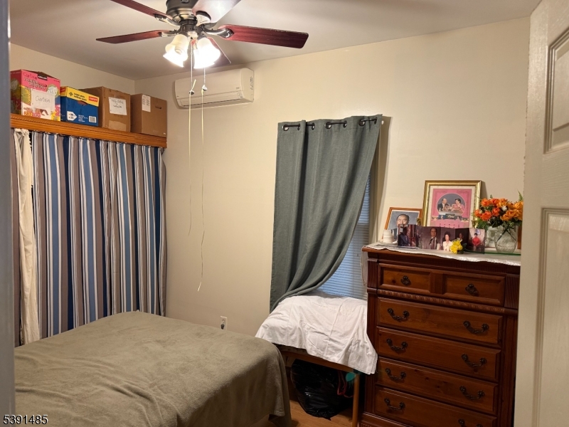 27 Passaic Avenue, Unit 2 Nutley, NJ 07110 - Photo 6 of 18 a bedroom with a bed and a chandelier