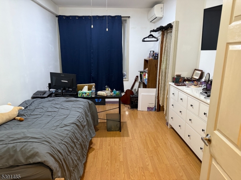 27 Passaic Avenue, Unit 2 Nutley, NJ 07110 - Photo 8 of 18 a bedroom with a bed and a flat tv screen on the dresser