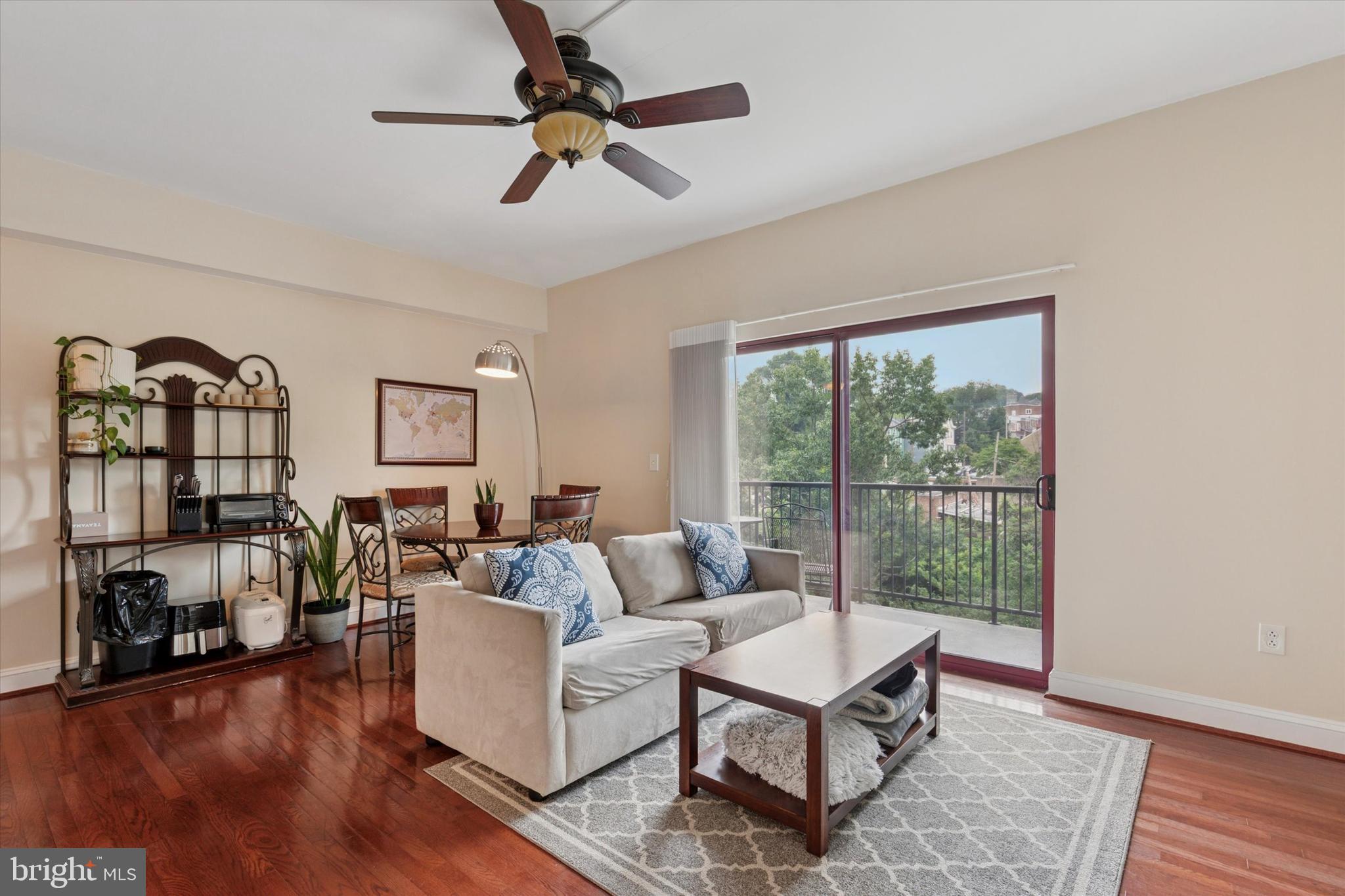 3750 Main Street, Unit 709 Philadelphia, PA 19127 - Photo 5 of 15 a living room with furniture a flat screen tv and a floor to ceiling window