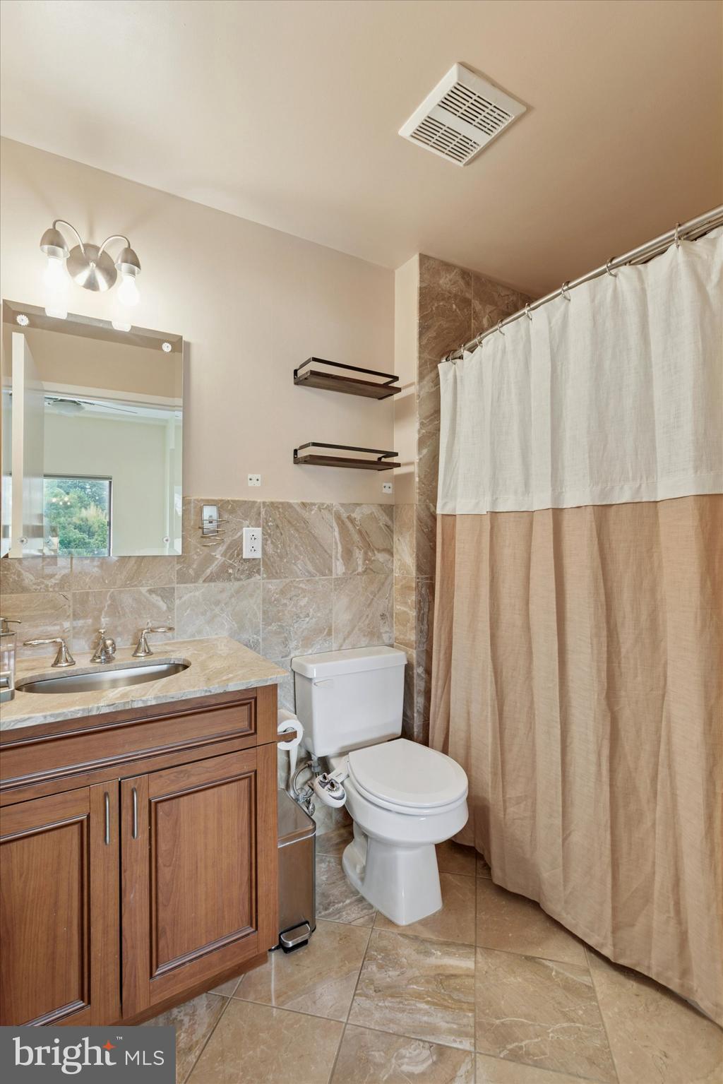 3750 Main Street, Unit 709 Philadelphia, PA 19127 - Photo 10 of 15 a bathroom with a granite countertop sink a toilet and a mirror