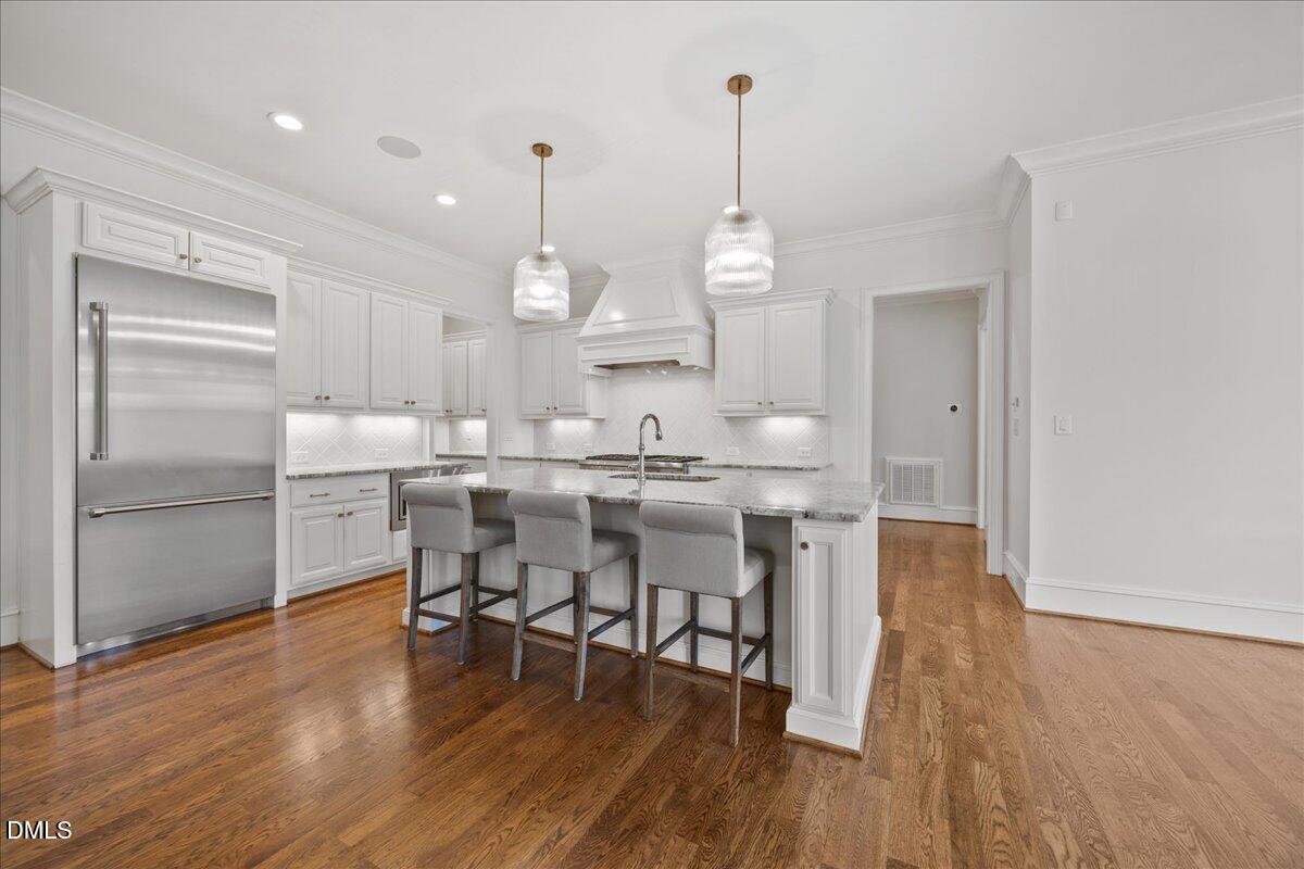 325 Forest Bridge Road Youngsville, NC 27596 - Photo 17 of 99 a kitchen with stainless steel appliances a dining table chairs stove and wooden floor