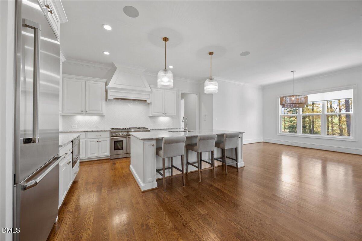 325 Forest Bridge Road Youngsville, NC 27596 - Photo 19 of 99 a kitchen with a table chairs wooden floors and a view of living room