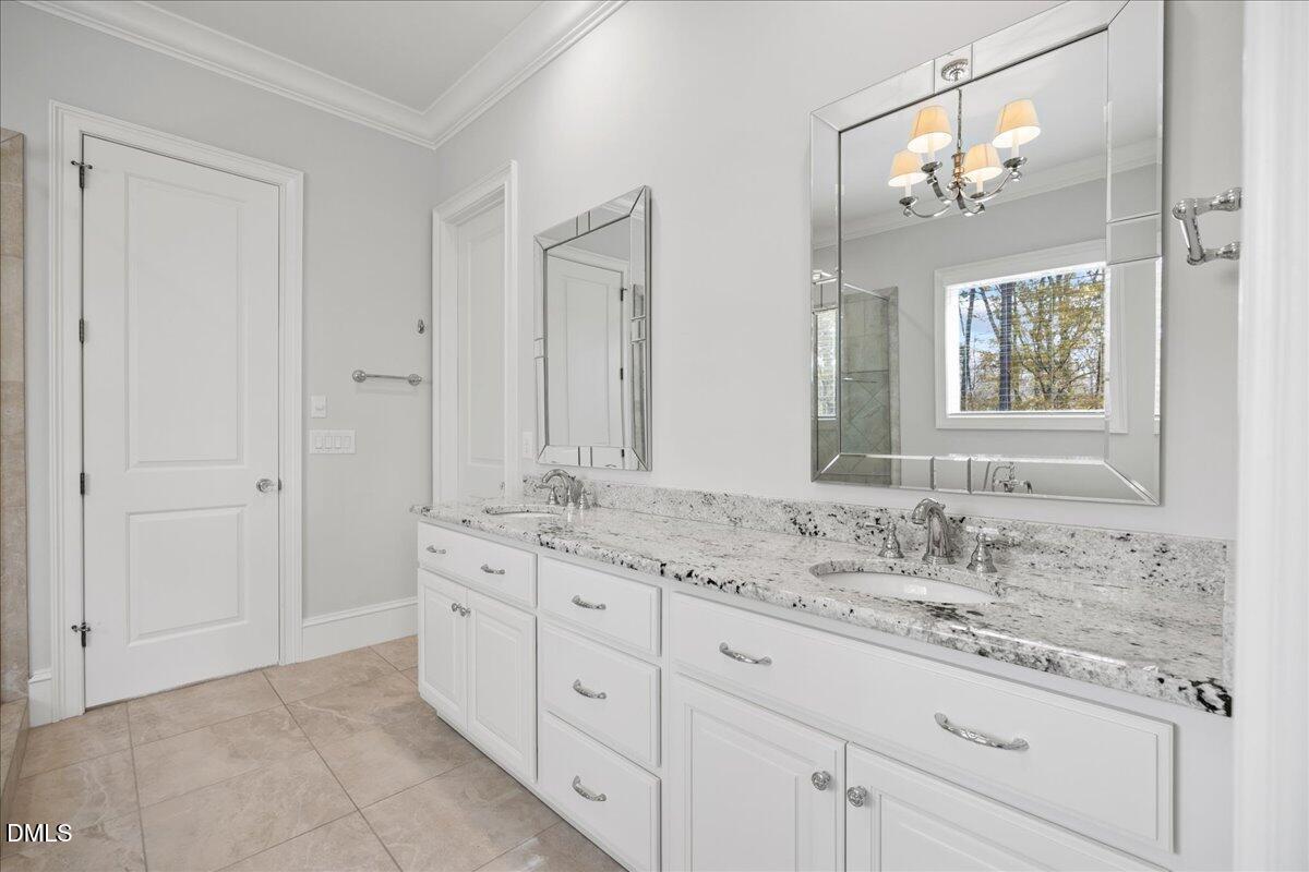 325 Forest Bridge Road Youngsville, NC 27596 - Photo 28 of 99 a bathroom with a granite countertop sink two mirror and a window