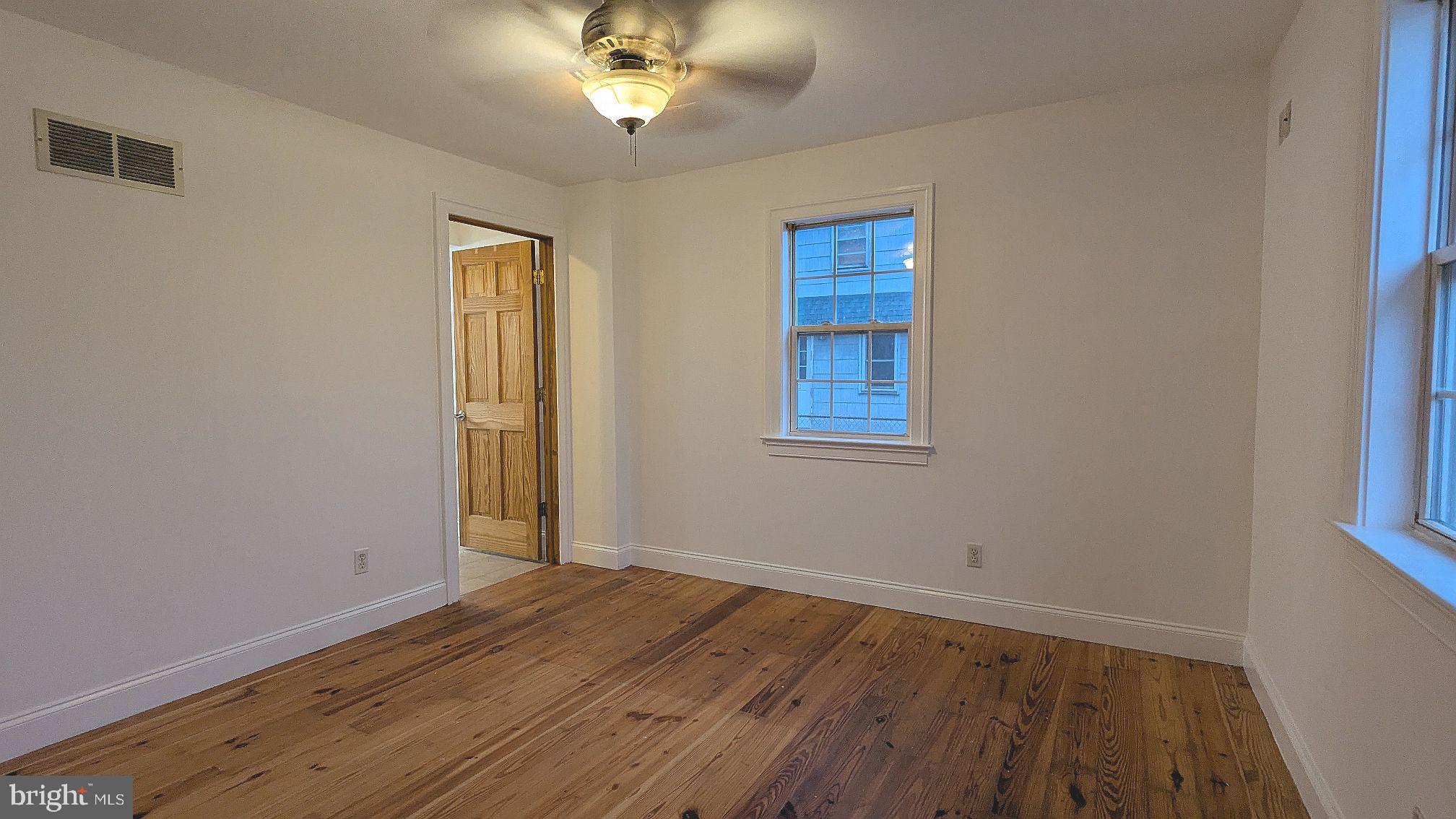 21 Sycamore Road Pennsville, NJ 08070 - Photo 23 of 31 a view of an empty room with wooden floor and a window