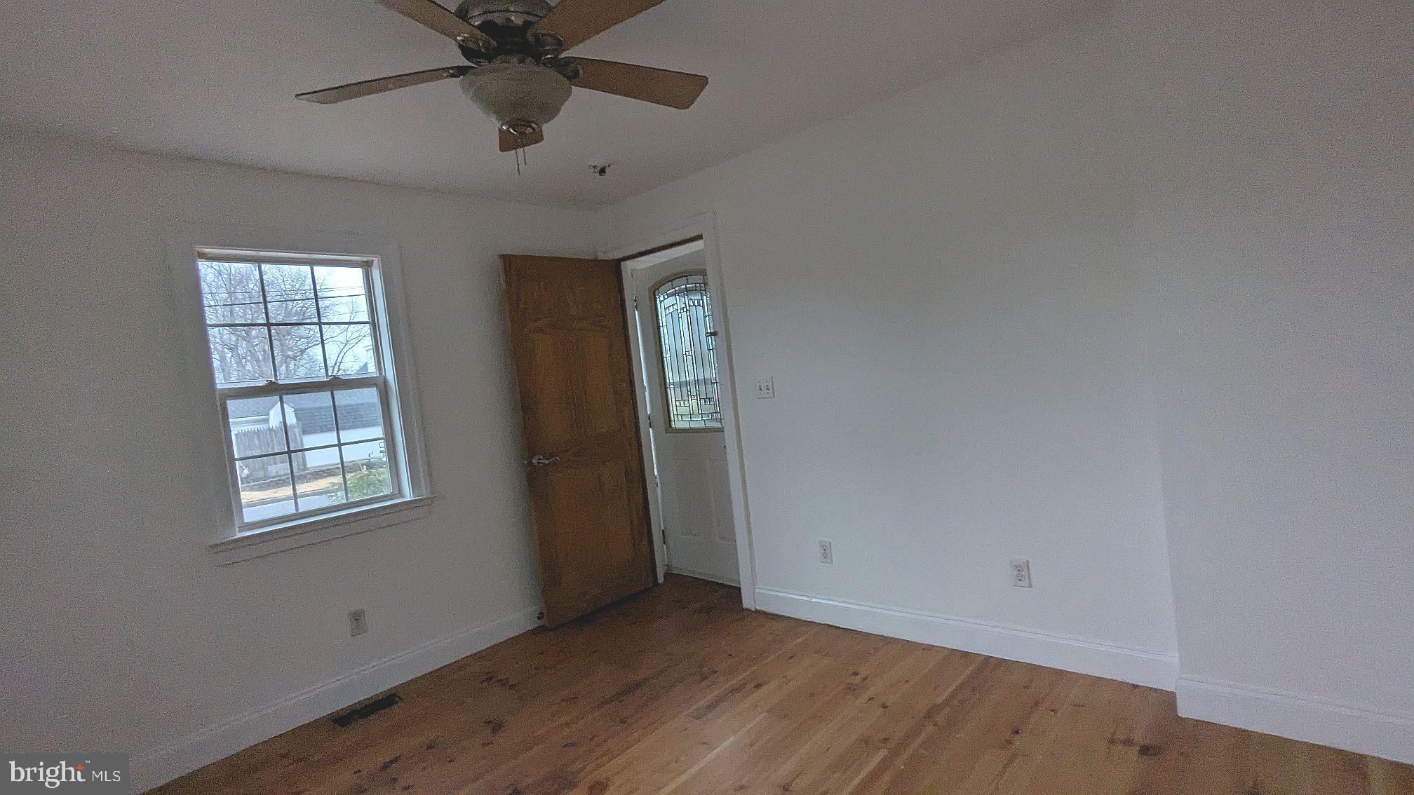 21 Sycamore Road Pennsville, NJ 08070 - Photo 5 of 31 a view of an empty room with a window and a chandelier fan