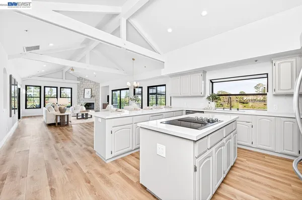 a kitchen with white cabinets and a window