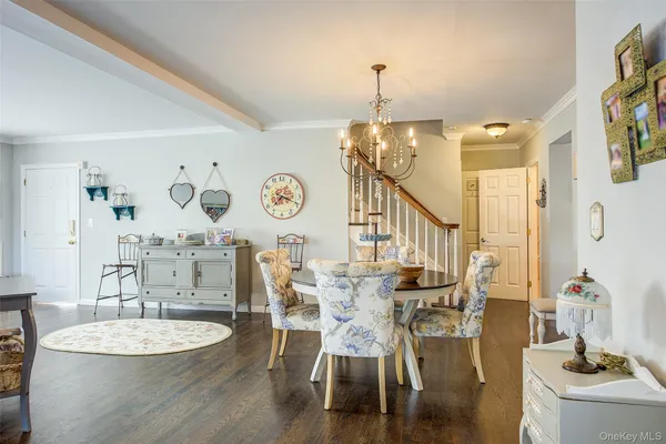 a dining room with wooden floor a chandelier a wooden table and chairs