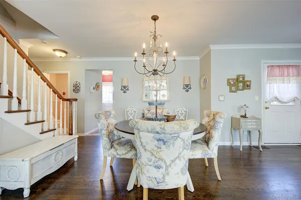 a view of a dining room with furniture a chandelier and wooden floor