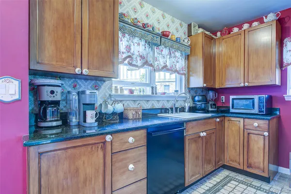 a kitchen with stainless steel appliances granite countertop a sink dishwasher and cabinets with wooden floor