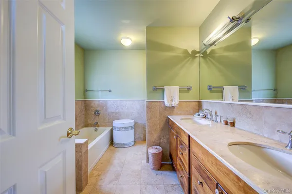 a spacious bathroom with a granite countertop sink mirror and a bathtub