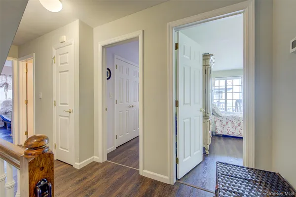 a view of a hallway with bathroom and wooden floor