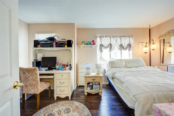 a bedroom with a bed and a wooden floor