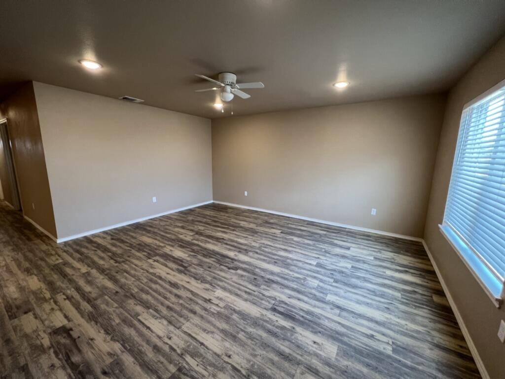 7410 5th Street, Unit 1 Lubbock, TX 79416 - Photo 10 of 19 wooden floor in an empty room with a window