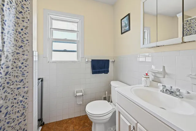 a bathroom with a sink a toilet and a mirror