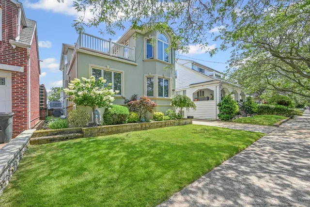 a front view of a house with a yard and potted plants