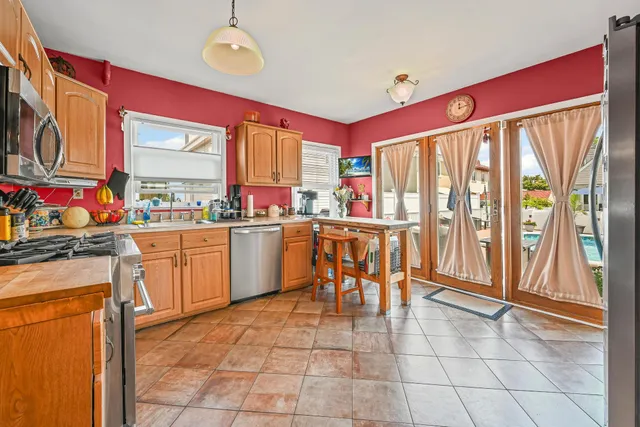 a large kitchen with a stove a sink dishwasher and a refrigerator
