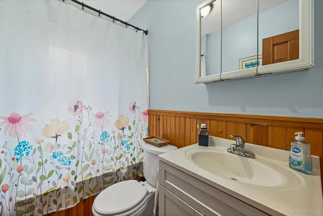 a bathroom with a sink a toilet and shower curtain