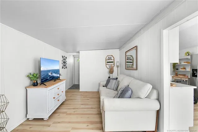 a bedroom with a bed a dresser and potted plants