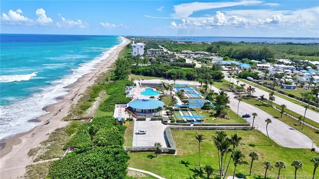a view of swimming pool with a table and chairs under an umbrella