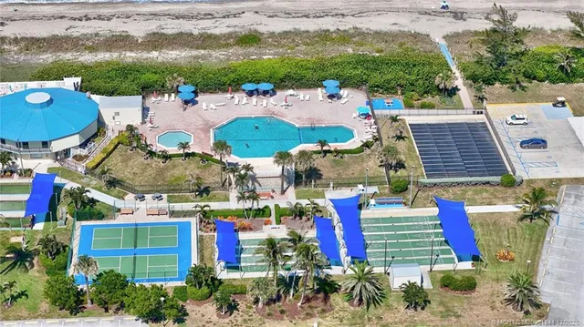 a view of a swimming pool with a bench and lawn chairs