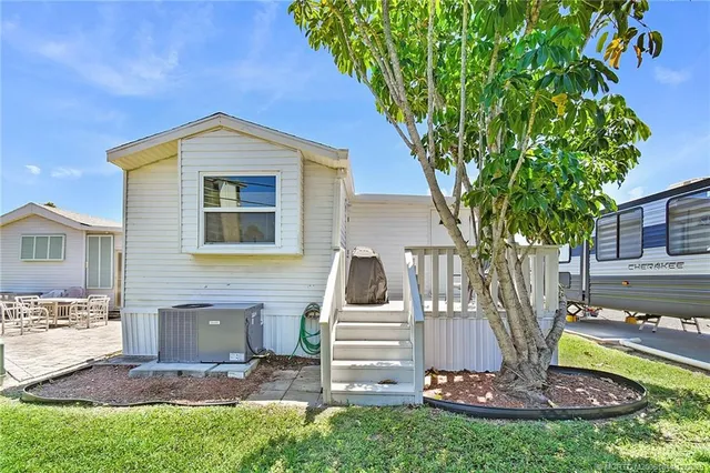 a kitchen with stainless steel appliances kitchen island granite countertop a refrigerator a stove top oven a sink dishwasher and wooden floor