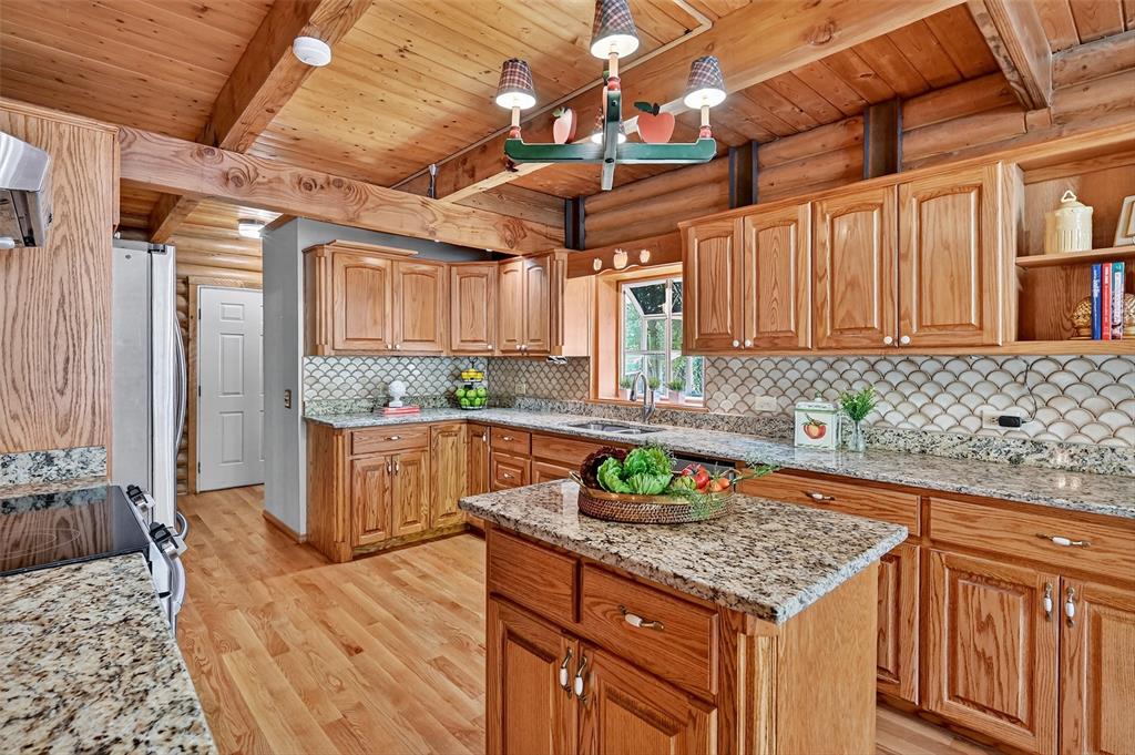 570 Ayres Road Bells, TX 75414 - Photo 17 of 39 Kitchen with a wood ceiling with exposed beams, light wood-style floors, stainless steel electric range, light stone countertops, and tasteful backsplash