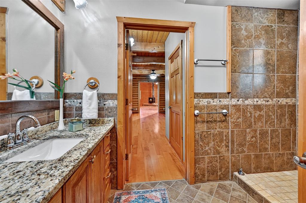 570 Ayres Road Bells, TX 75414 - Photo 23 of 39 Bathroom featuring vanity, tiled shower, and tile walls