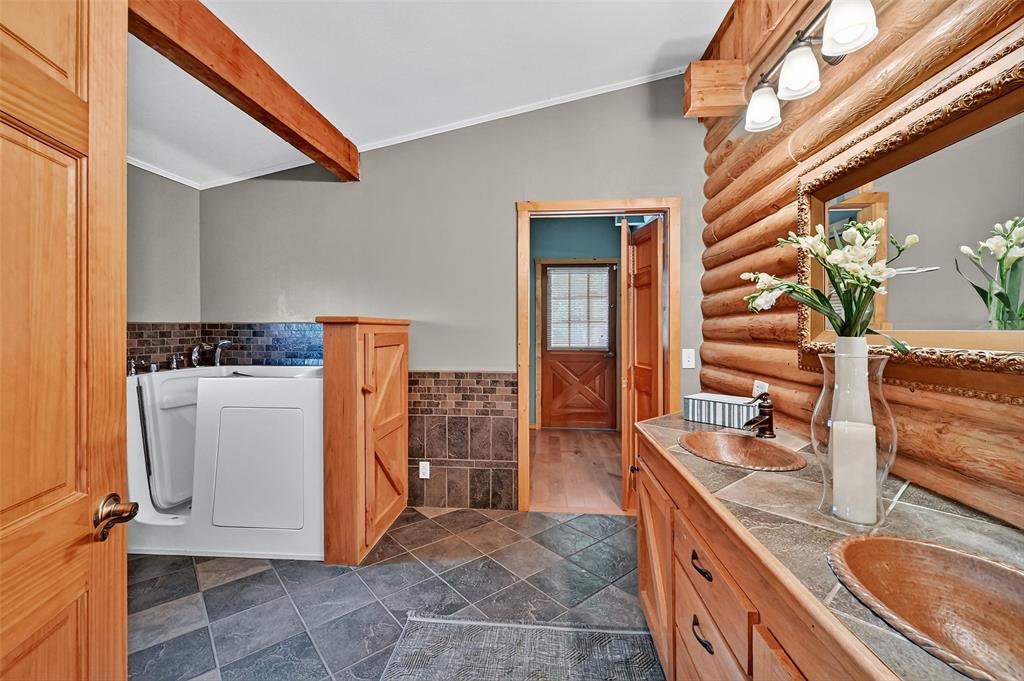 570 Ayres Road Bells, TX 75414 - Photo 25 of 39 Bathroom featuring log walls, crown molding, tile walls, and wainscoting