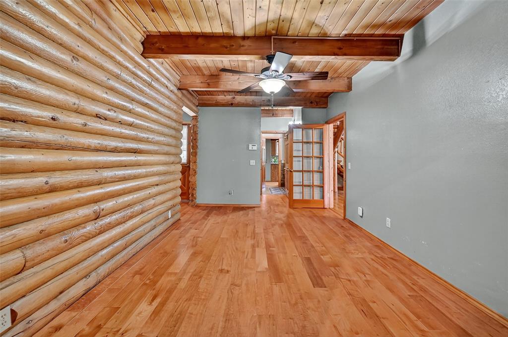 570 Ayres Road Bells, TX 75414 - Photo 32 of 39 Spare room featuring hardwood / wood-style flooring, a wood ceiling with exposed beams, ceiling fan, and rustic walls