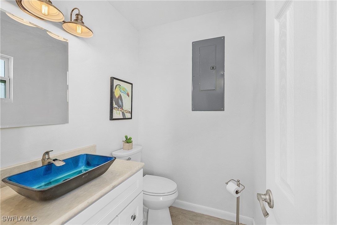 3128 Stringfellow Road St. James City, FL 33956 - Photo 21 of 50 a bathroom with a sink mirror and toilet