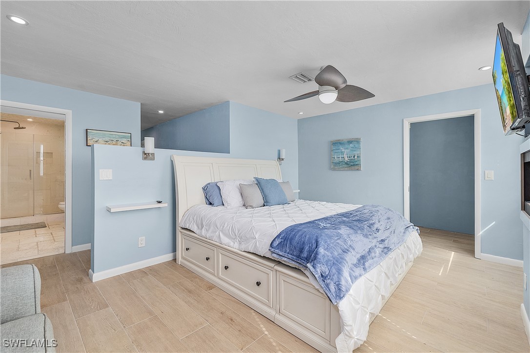 3128 Stringfellow Road St. James City, FL 33956 - Photo 27 of 50 a spacious bedroom with a bed and a ceiling fan